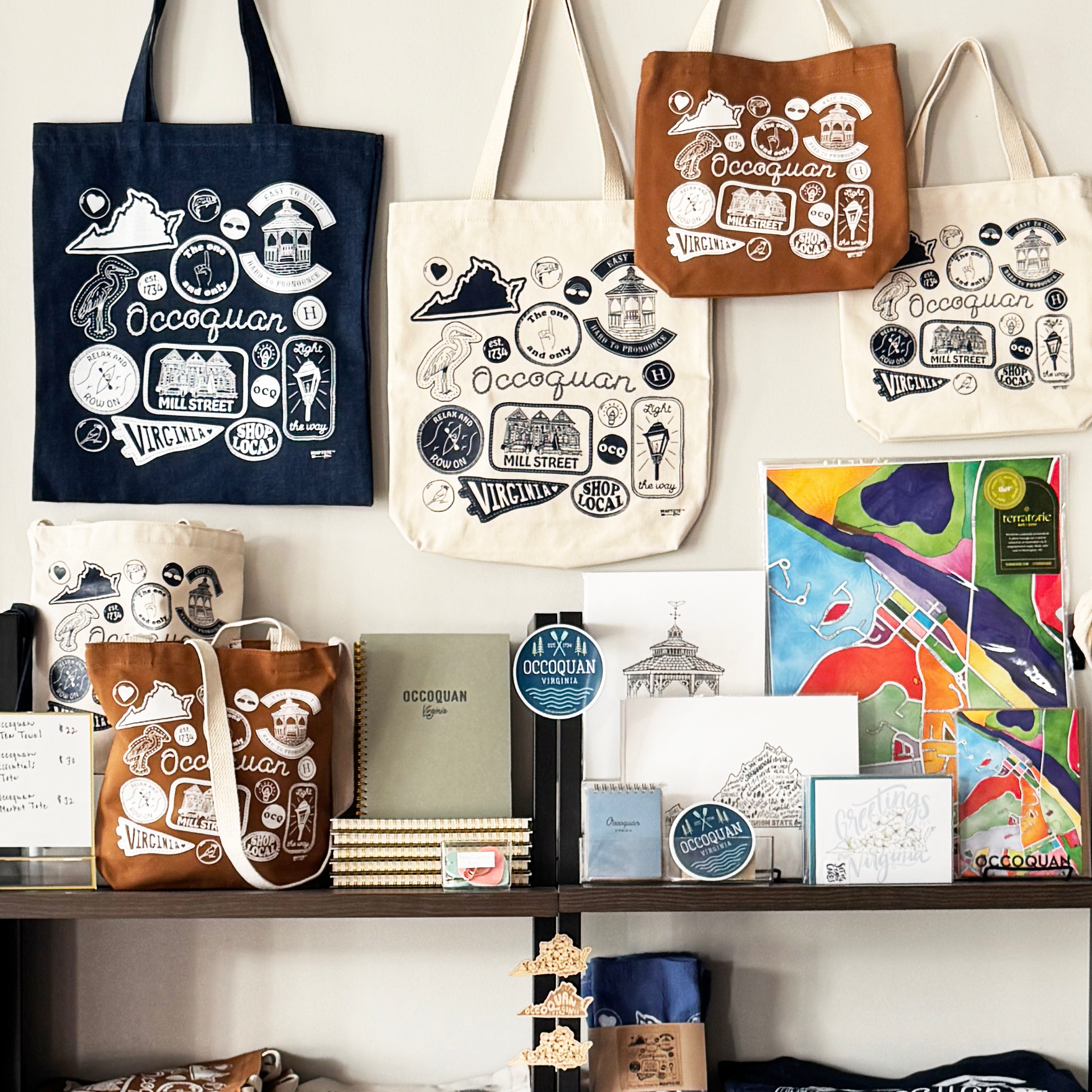 Collection of custom tote bags other merchandise on a shelf with a white background.